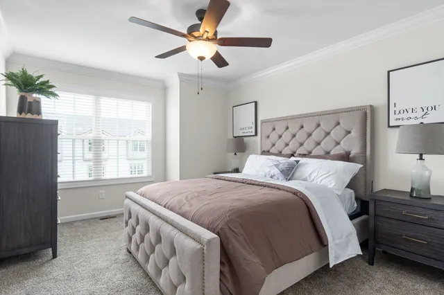 a bedroom with a large bed and a chandelier