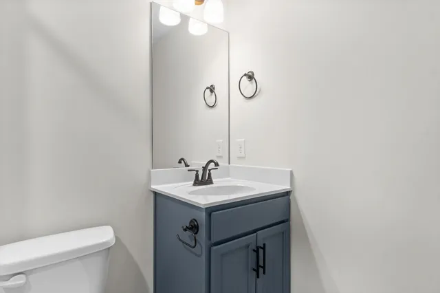 a bathroom with a sink a toilet and mirror