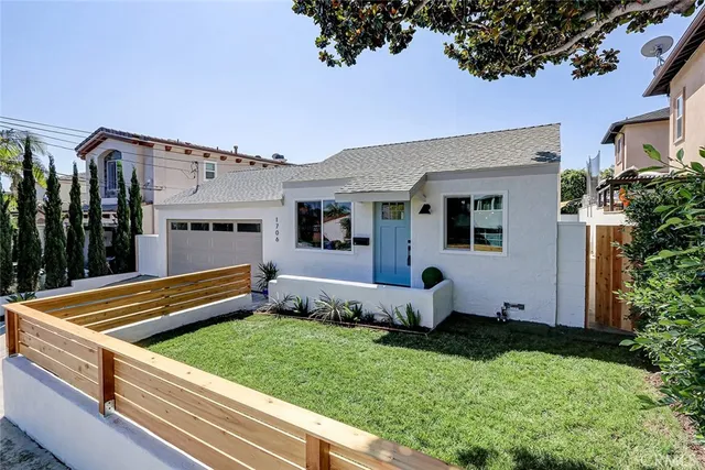 a backyard of a house with potted plants and large tree
