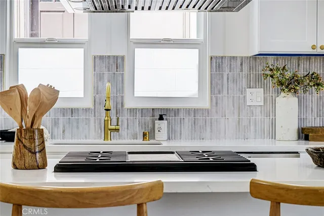 a kitchen with a stove and a white wooden cabinets