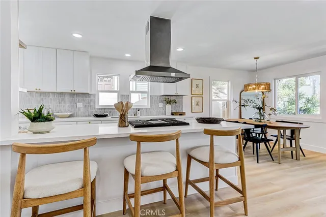 a kitchen with stainless steel appliances granite countertop table chairs sink and cabinets