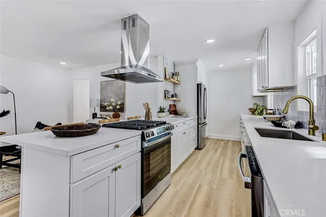 a kitchen with stainless steel appliances a sink stove and refrigerator