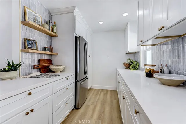a kitchen with stainless steel appliances a sink a window and white cabinets
