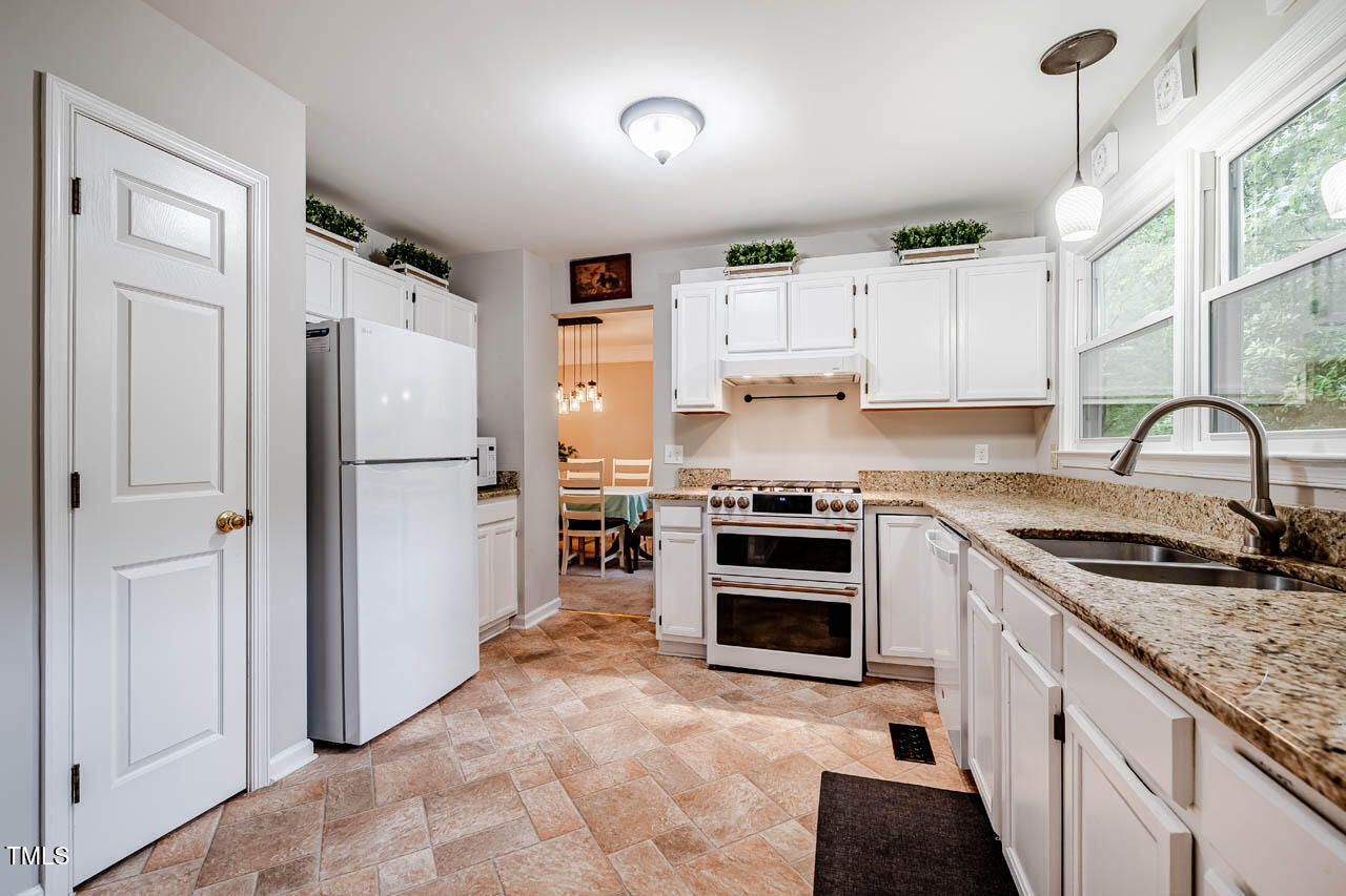 8 Wexford Drive Durham, NC 27713 - Photo 10 of 38 a kitchen with granite countertop a refrigerator stove and sink