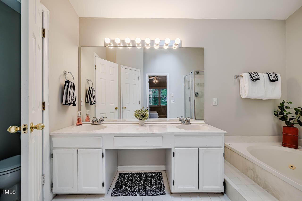 8 Wexford Drive Durham, NC 27713 - Photo 22 of 38 a bathroom with a sink vanity tub and a mirror