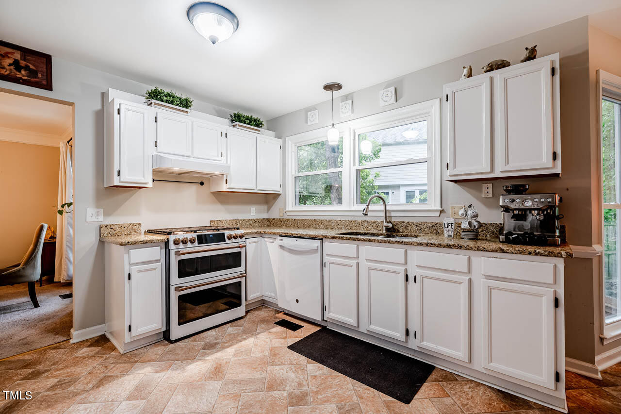 8 Wexford Drive Durham, NC 27713 - Photo 9 of 38 a kitchen with stainless steel appliances granite countertop a stove a sink and white cabinets