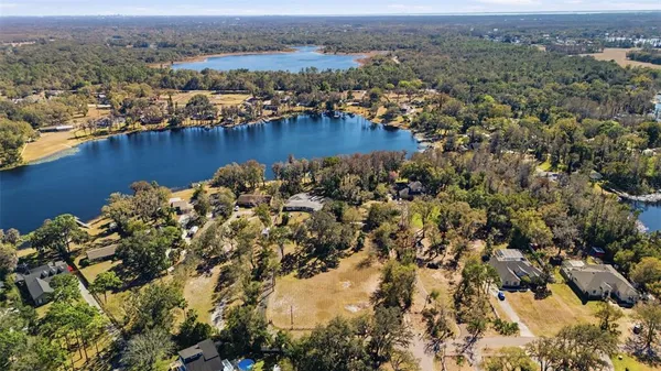 an aerial view of residential houses with outdoor space and lake view
