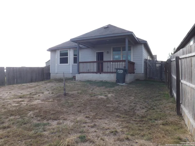 a view of a house with wooden fence