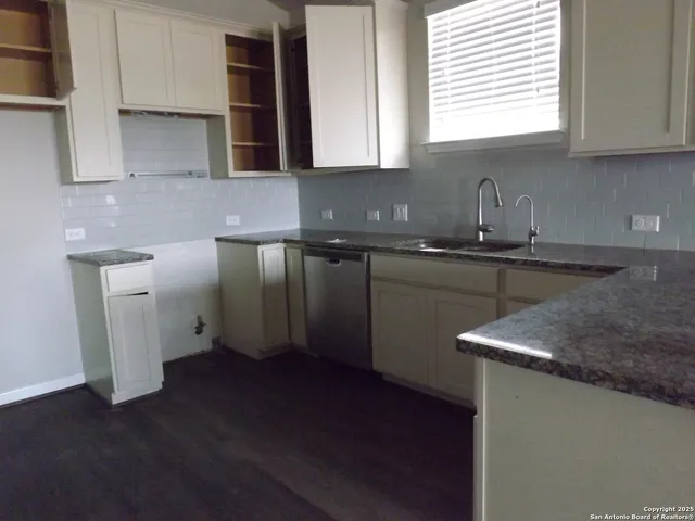 a kitchen with a sink cabinets and window