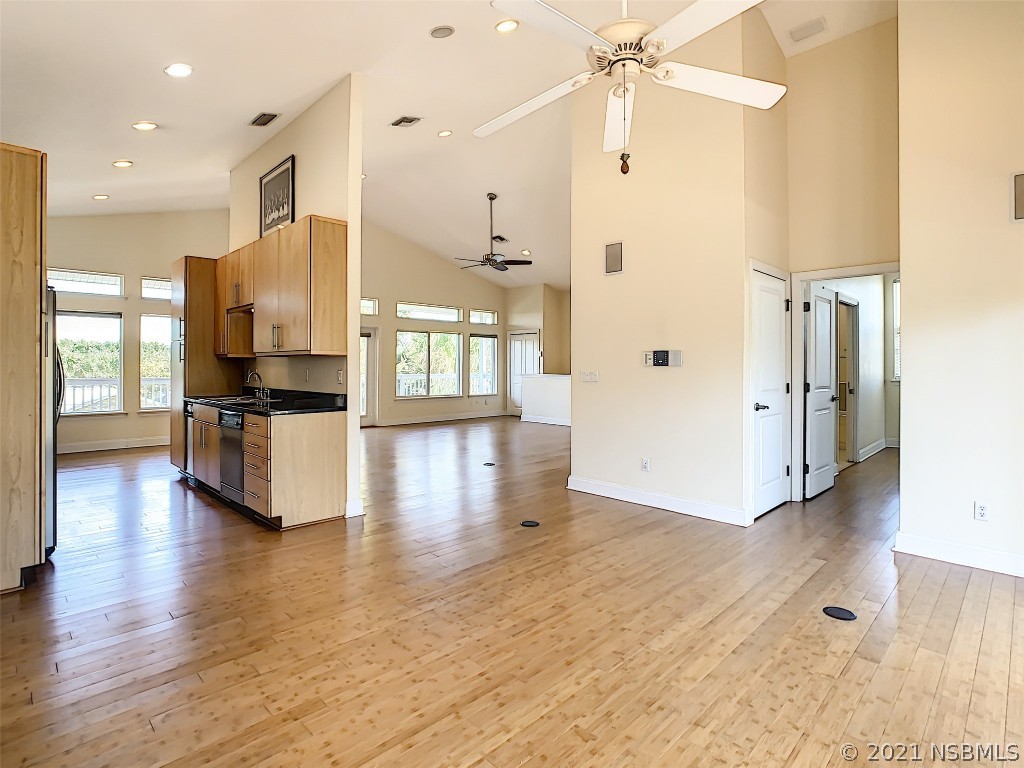 6273 Engram Road New Smyrna Beach, FL 32169 - Photo 12 of 34 a view of kitchen with stainless steel appliances kitchen island wooden floors and living room view