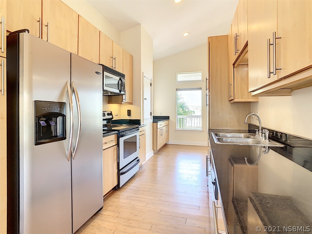 6273 Engram Road New Smyrna Beach, FL 32169 - Photo 14 of 34 a kitchen with stainless steel appliances granite countertop a refrigerator a stove and a sink