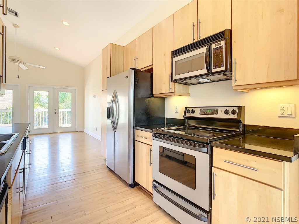 6273 Engram Road New Smyrna Beach, FL 32169 - Photo 16 of 34 a kitchen with stainless steel appliances granite countertop a stove microwave and refrigerator