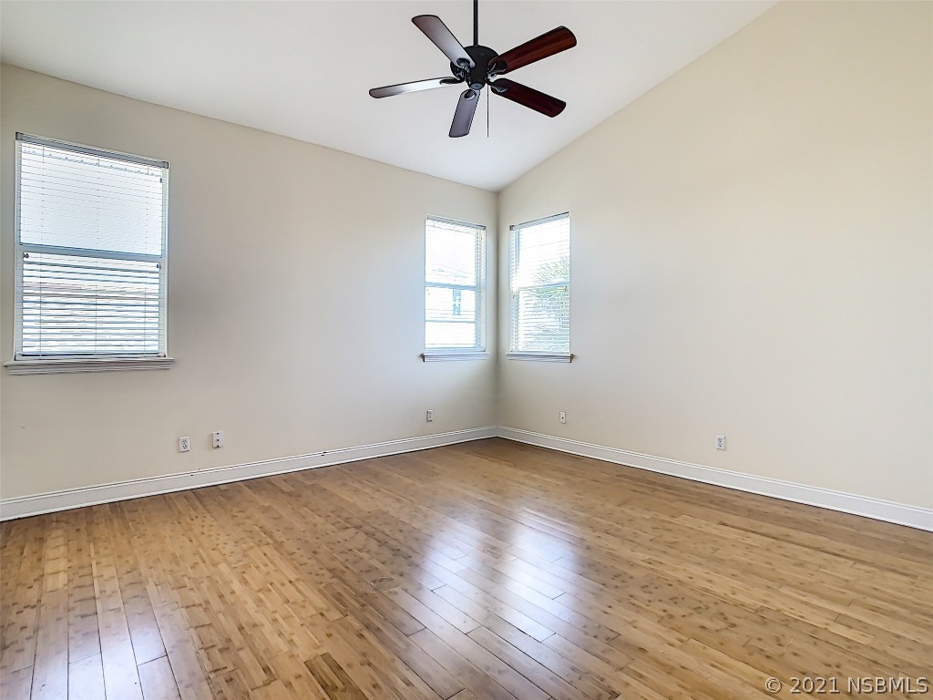 6273 Engram Road New Smyrna Beach, FL 32169 - Photo 20 of 34 an empty room with wooden floor fan and windows