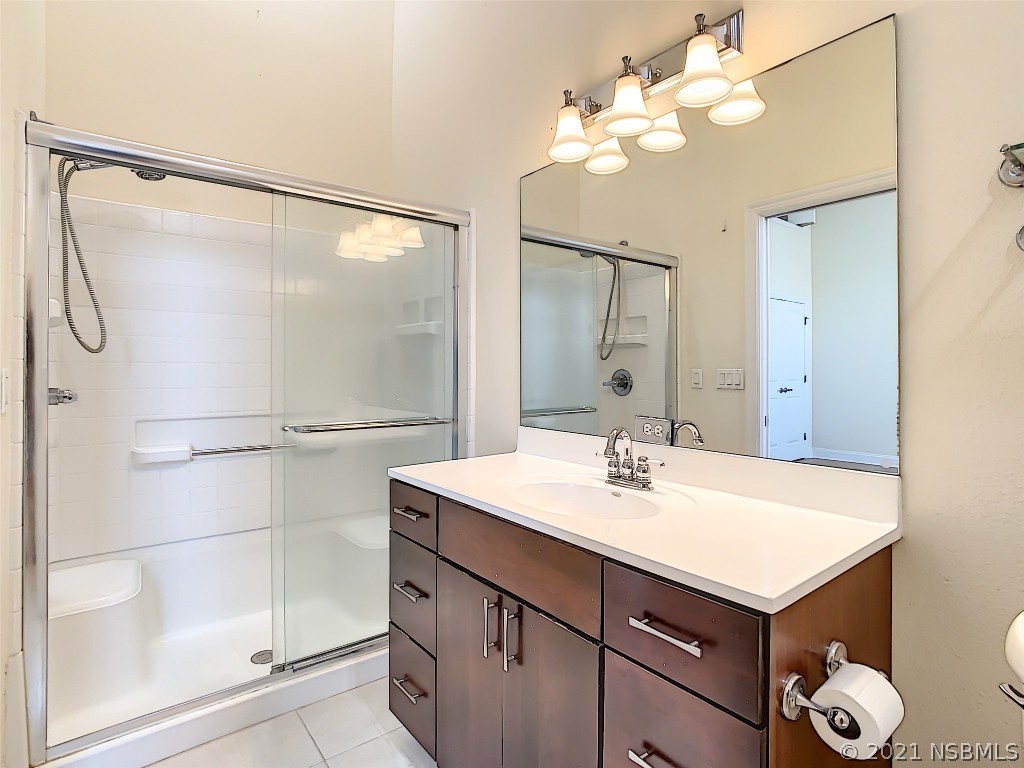 6273 Engram Road New Smyrna Beach, FL 32169 - Photo 22 of 34 a bathroom with a sink vanity mirror and shower
