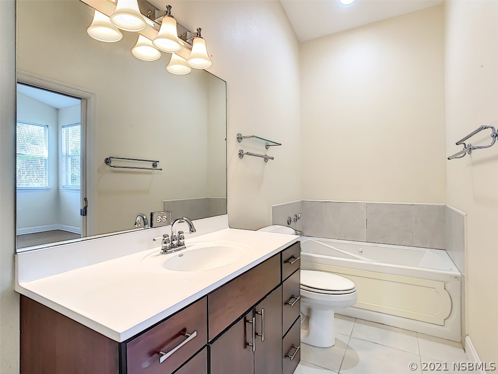 6273 Engram Road New Smyrna Beach, FL 32169 - Photo 23 of 34 a bathroom with a sink a toilet and a bathtub
