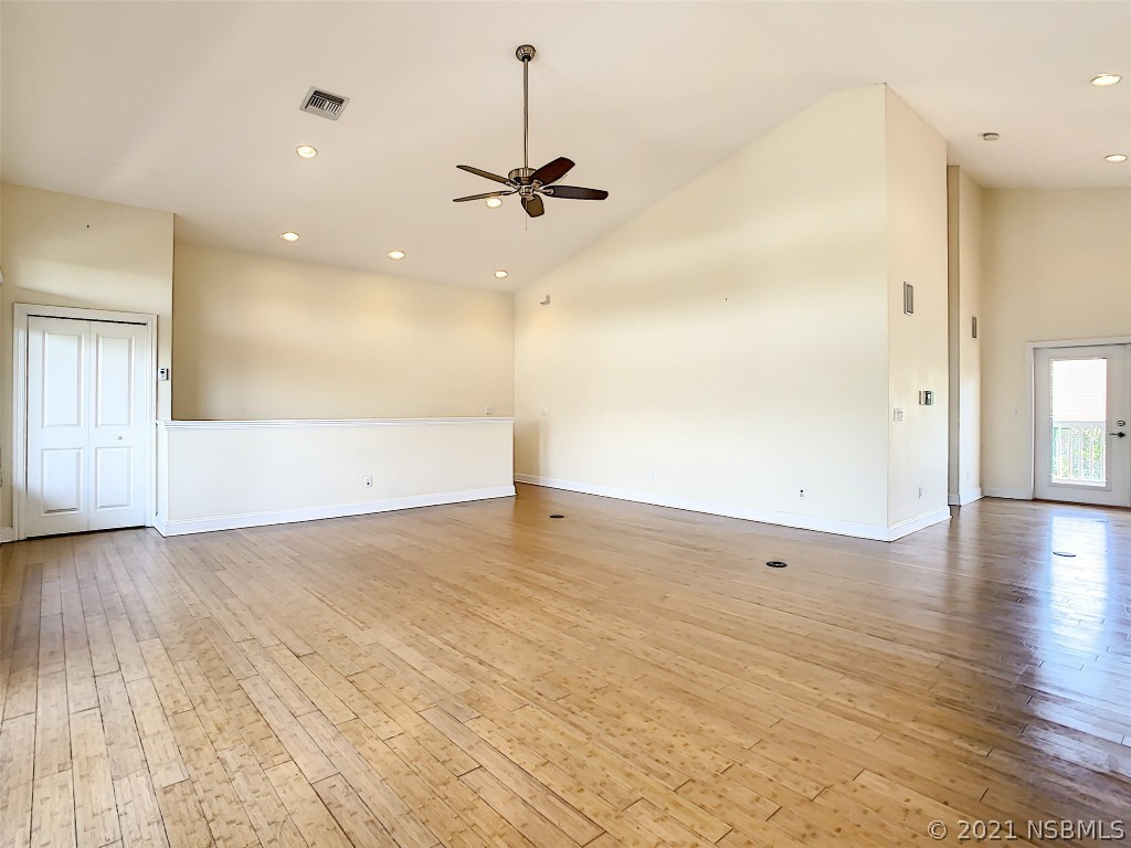 6273 Engram Road New Smyrna Beach, FL 32169 - Photo 6 of 34 an empty room with wooden floor and windows
