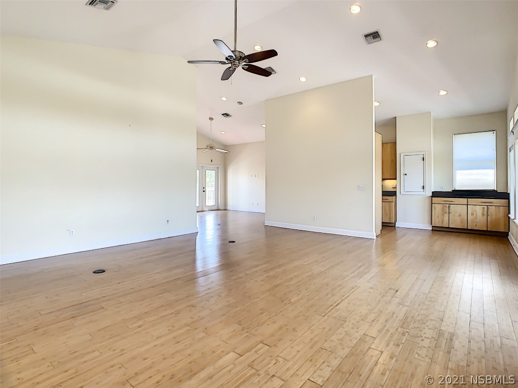 6273 Engram Road New Smyrna Beach, FL 32169 - Photo 10 of 34 a view of a kitchen with a dishwasher a kitchen island wooden floor and a window