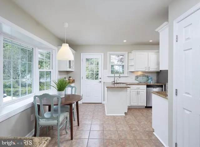 a kitchen with a dining table chairs and refrigerator