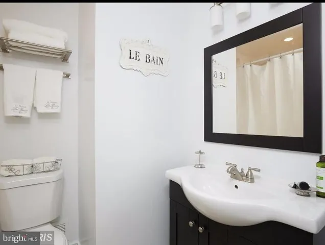 a bathroom with a sink a toilet and mirror