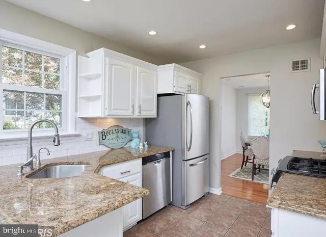 a kitchen with granite countertop a refrigerator and a sink