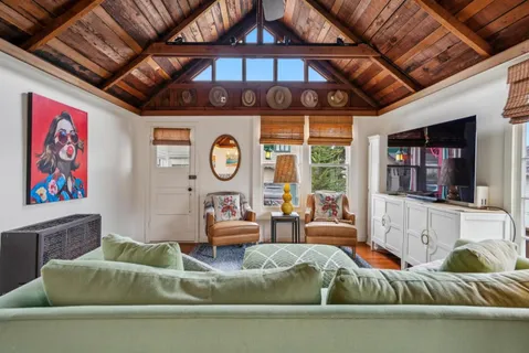 a living room with furniture a flat screen tv and a clock