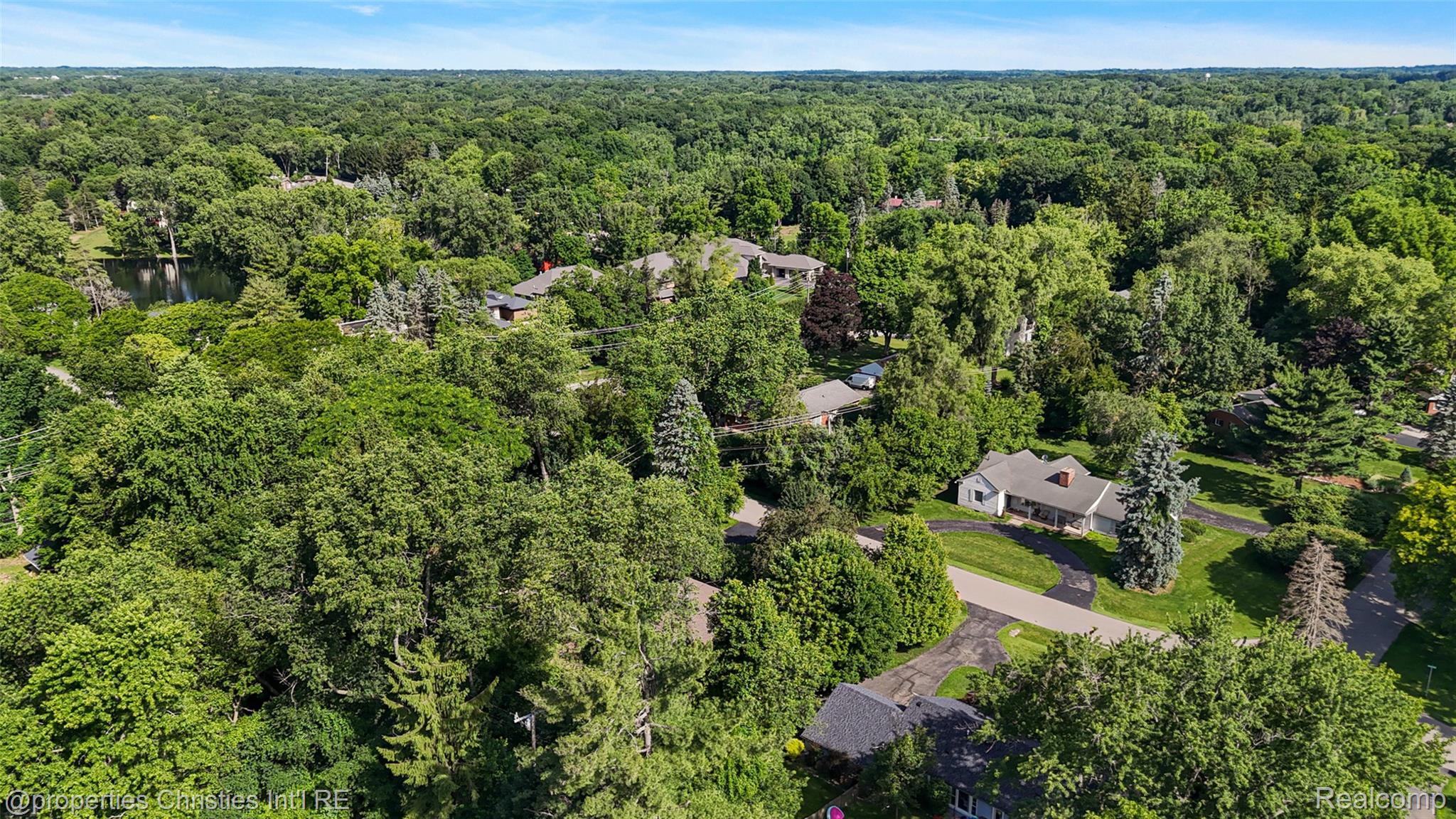 27331 Gardenway Road Franklin, MI 48025 - Photo 17 of 65 Residential property featuring a light-colored exterior and a dark roof, surrounded by mature trees and lush green landscaping