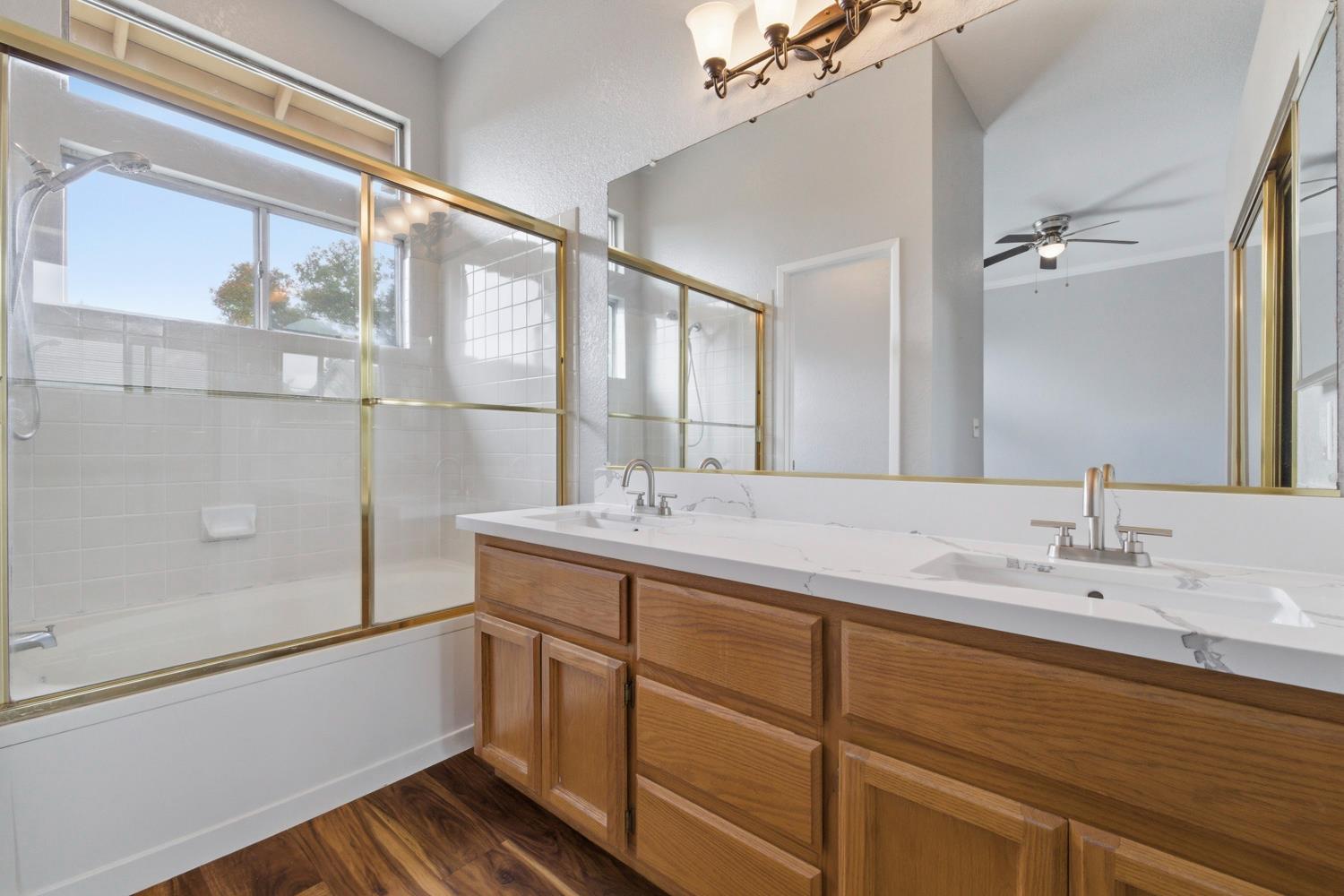 969 Colson Way Galt, CA 95632 - Photo 22 of 38 a bathroom with a double vanity sink and mirror with bathtub