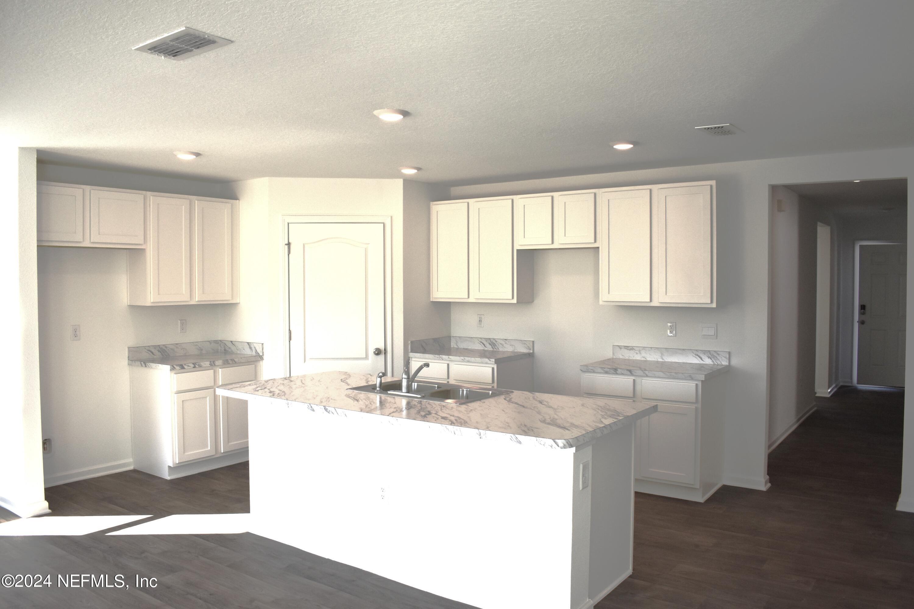 12725 European Beech Road Jacksonville, FL 32218 - Photo 14 of 36 a kitchen with a sink stove and cabinets