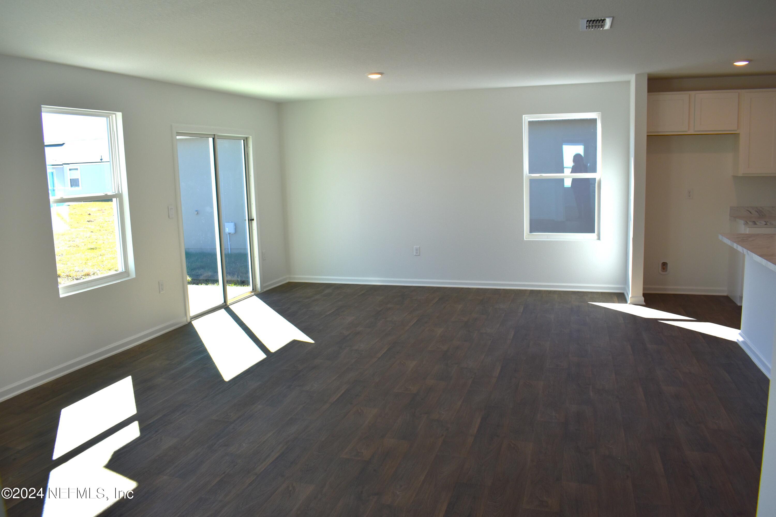12725 European Beech Road Jacksonville, FL 32218 - Photo 16 of 36 an empty room with wooden floor and windows
