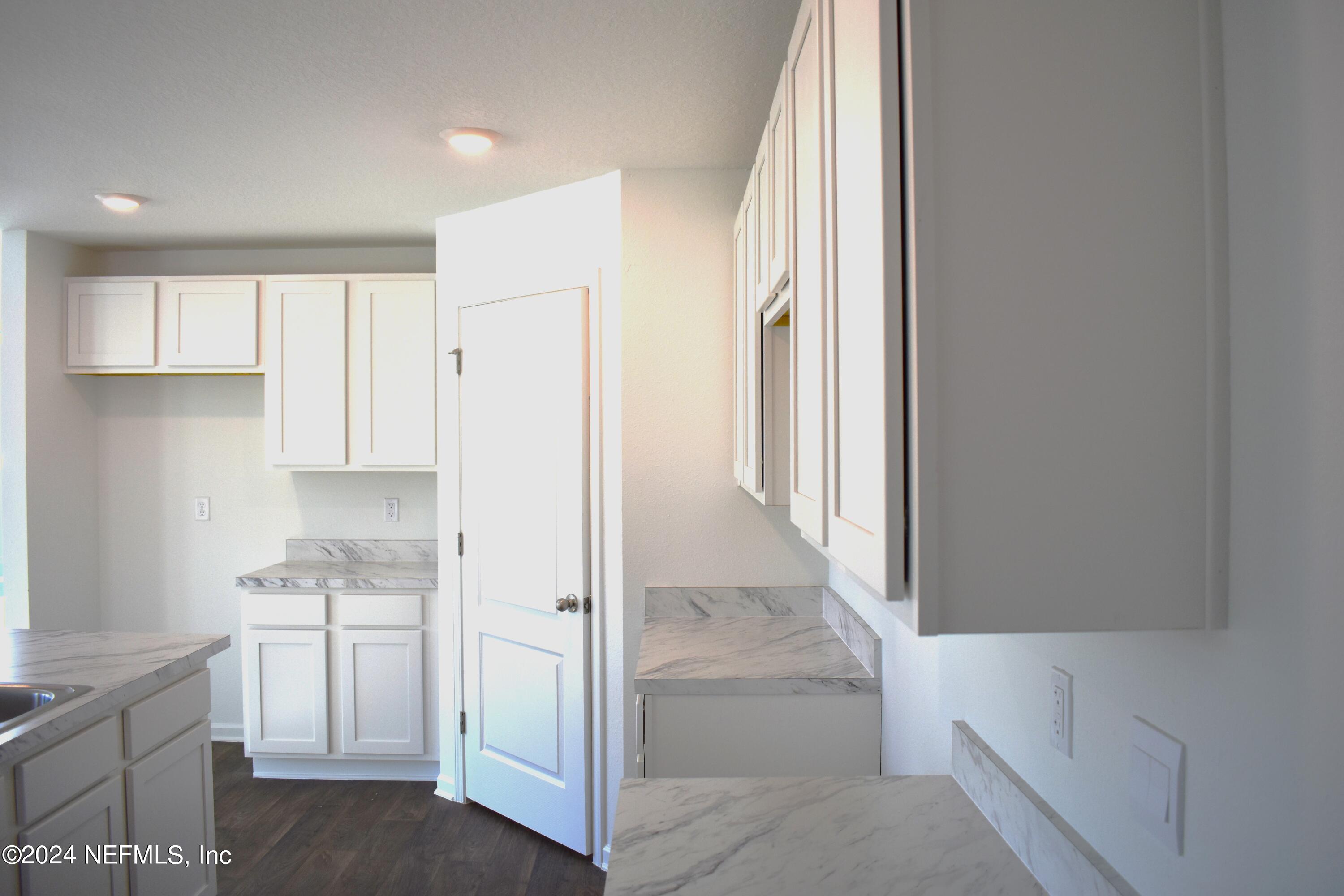 12725 European Beech Road Jacksonville, FL 32218 - Photo 10 of 36 a kitchen with white cabinets and white appliances