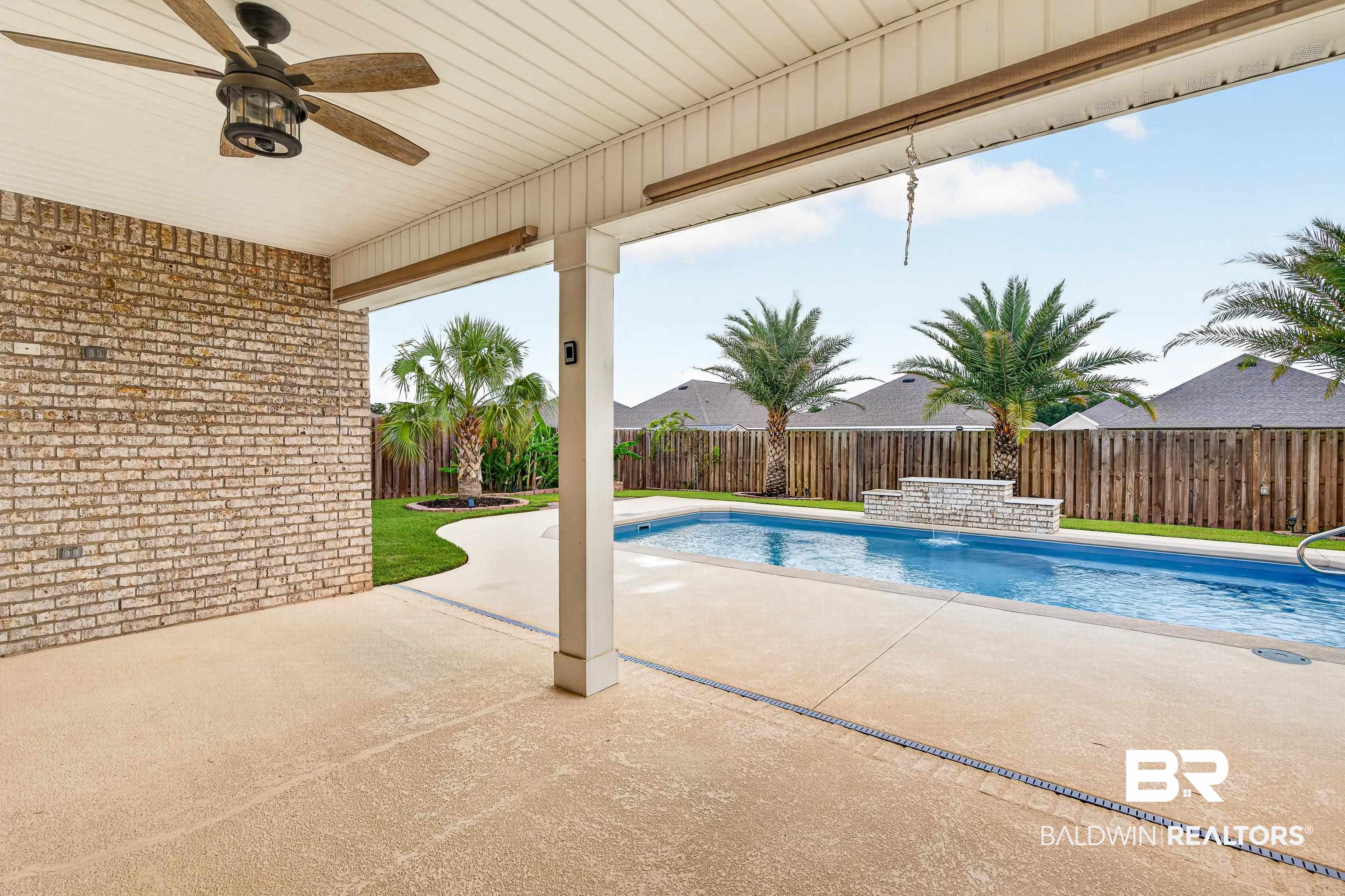 1724 Partridge Street Foley, AL 36535 - Photo 48 of 62 Covered patio featuring a ceiling fan, light-colored brick wall, and textured concrete flooring