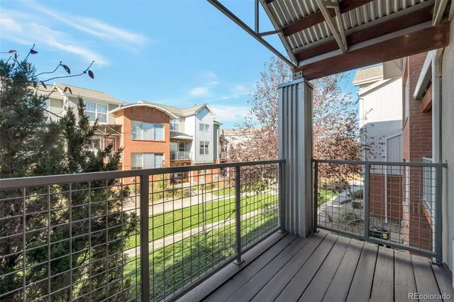 a view of roof deck with wooden floor and fence next to a yard