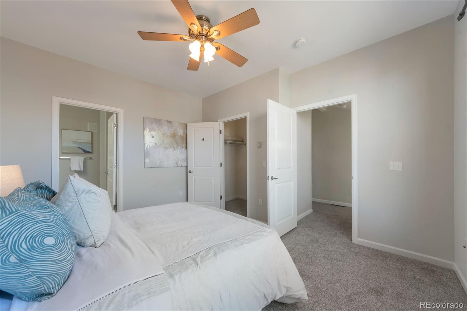 85 Uinta Way, Unit 603 Denver, CO 80230 - Photo 16 of 25 a bedroom with a large bed and a chandelier