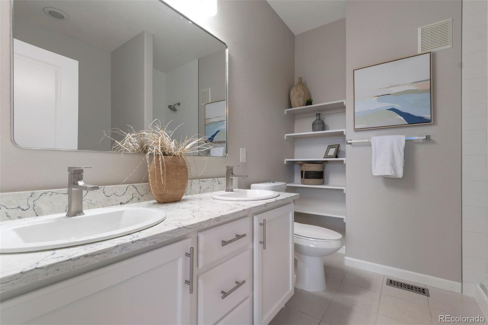 85 Uinta Way, Unit 603 Denver, CO 80230 - Photo 17 of 25 a bathroom with a granite countertop toilet sink and mirror
