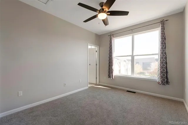 an empty room with a window and a fan