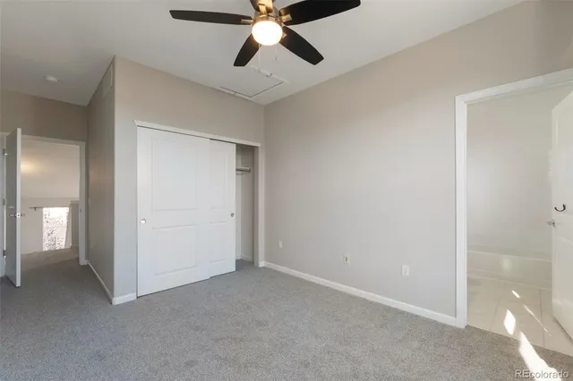 an empty room with closet and a chandelier fan