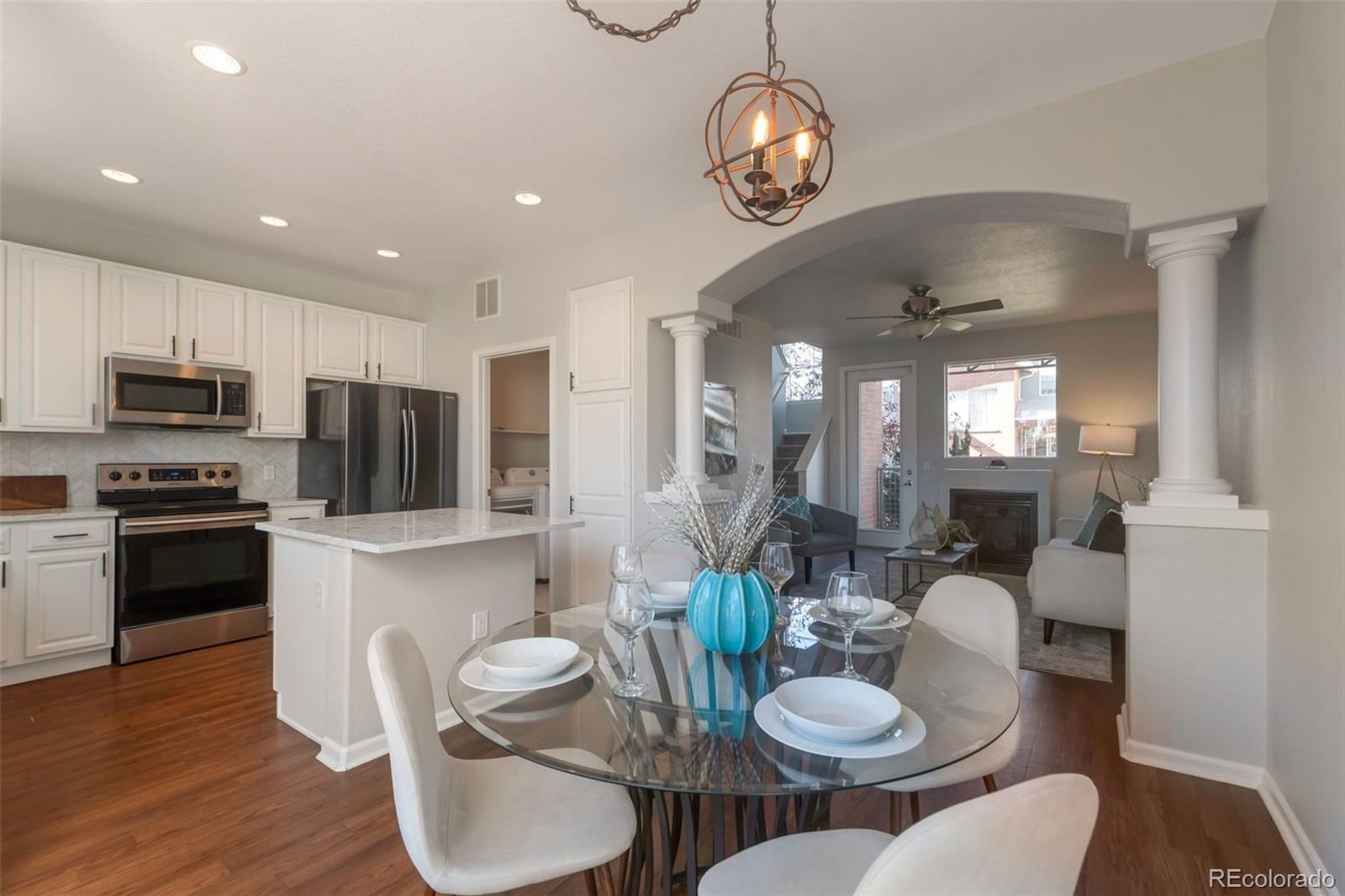 85 Uinta Way, Unit 603 Denver, CO 80230 - Photo 9 of 25 a kitchen with stainless steel appliances kitchen island granite countertop a dining table chairs and stove top oven