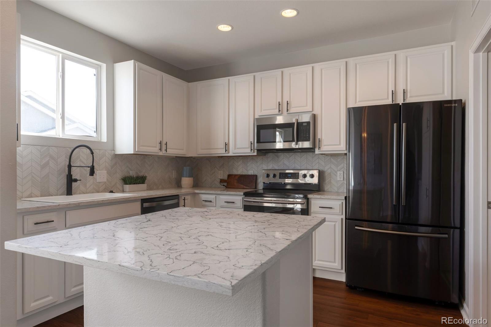 85 Uinta Way, Unit 603 Denver, CO 80230 - Photo 10 of 25 a kitchen with a refrigerator a sink a stove a microwave and cabinets