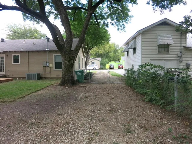 a view of a house with yard and a large tree