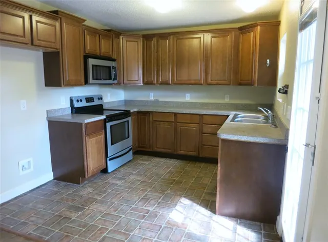 a kitchen with a sink stove and microwave