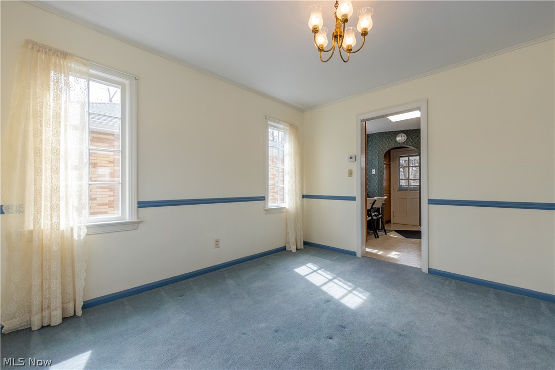 1050 Renfield Road Cleveland Heights, OH 44121 - Photo 10 of 41 Dining room with light carpet, ornamental molding, a chandelier, and a wealth of natural light