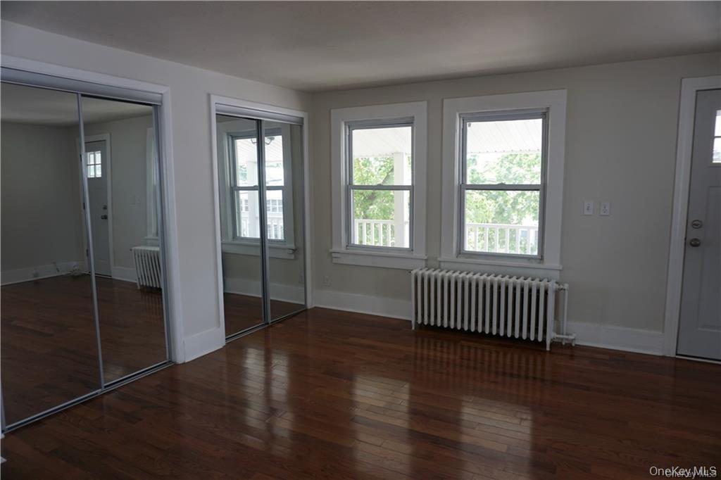 63 Spring Street Mount Kisco, NY 10549 - Photo 3 of 11 an empty room with wooden floor and windows