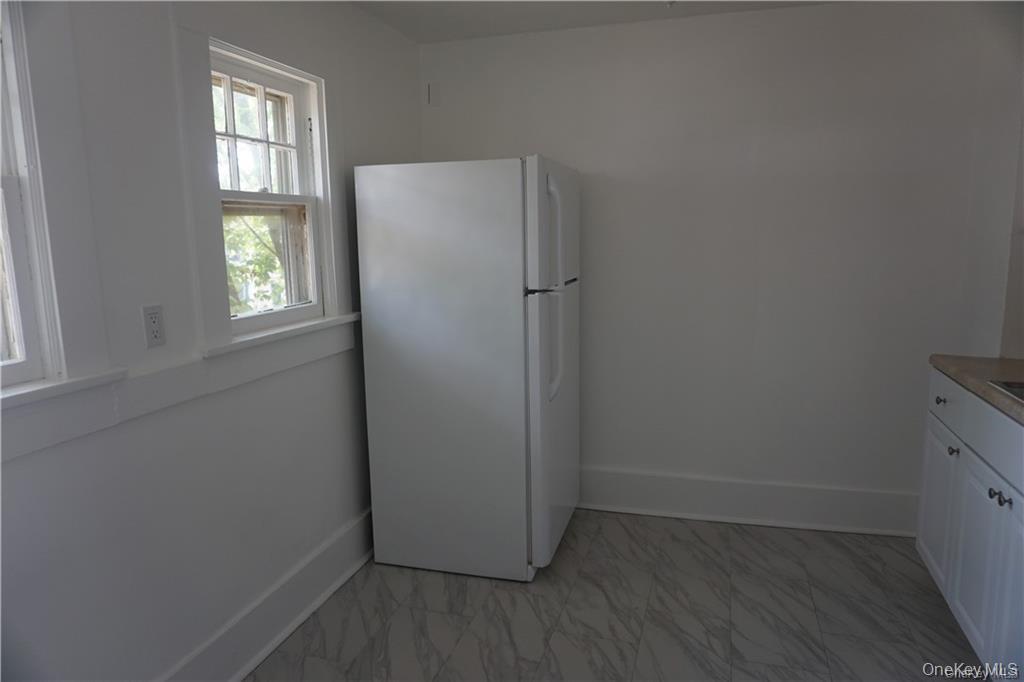 63 Spring Street Mount Kisco, NY 10549 - Photo 10 of 11 an empty room with wooden floor and windows