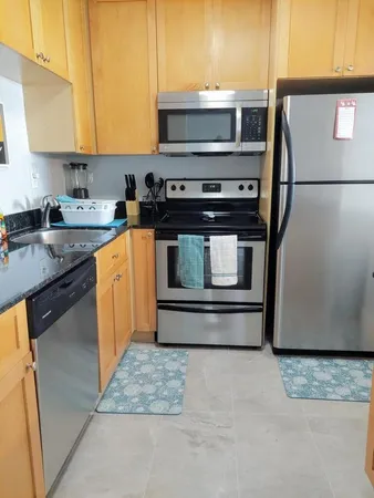 a kitchen with stainless steel appliances granite countertop a stove a microwave and a refrigerator
