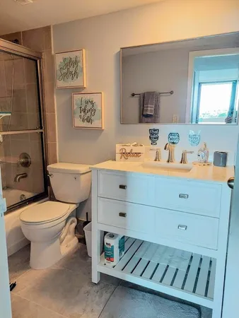 a bathroom with a sink mirror vanity and toilet