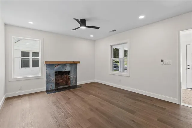 an empty room with windows and fireplace