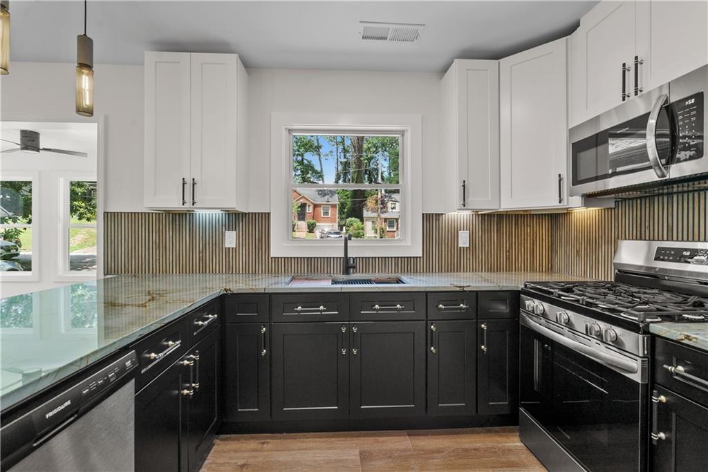 1658 Altadena Place Southwest Atlanta, GA 30311 - Photo 2 of 47 a kitchen with stainless steel appliances granite countertop a sink stove and cabinets
