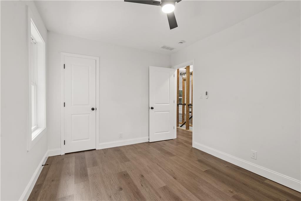1658 Altadena Place Southwest Atlanta, GA 30311 - Photo 22 of 47 an empty room with wooden floor chandelier fan and windows