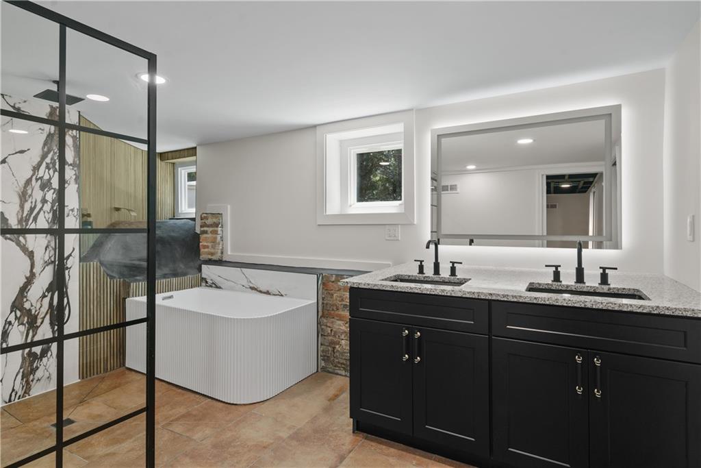 1658 Altadena Place Southwest Atlanta, GA 30311 - Photo 32 of 47 a spacious bathroom with a double vanity sink a mirror and a bathtub