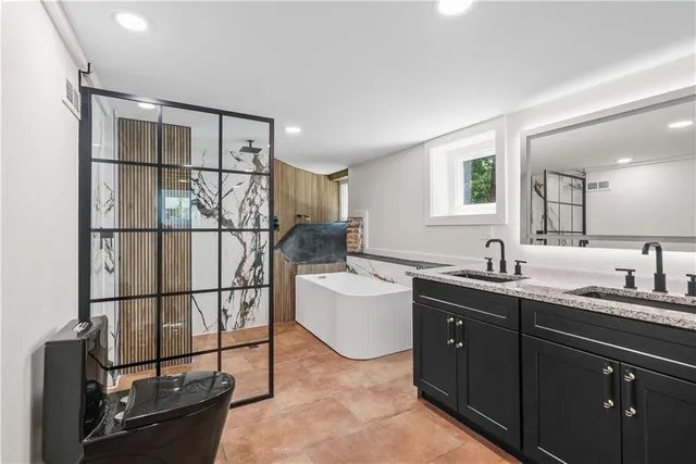 a spacious bathroom with a double vanity sink a mirror and shower